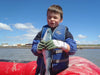 family member, little Owen, kissing a salmon we caught on our raft
