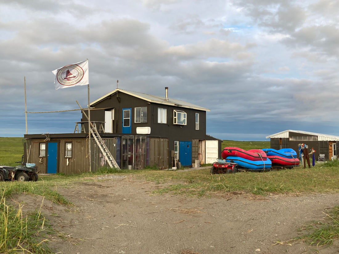 House on set net site with our stacked up rafts and Popsie flag flowing in the air