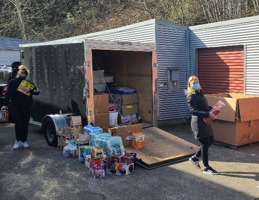 women loading up truck with lots of food and beverages for a few weeks at fish camp