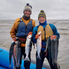 Our fisherm and and woman holding our sockeye salmon caught from out site net